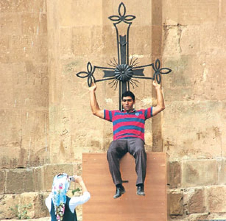 Sourb Khach waiting for mass while tourists pose for photos 
