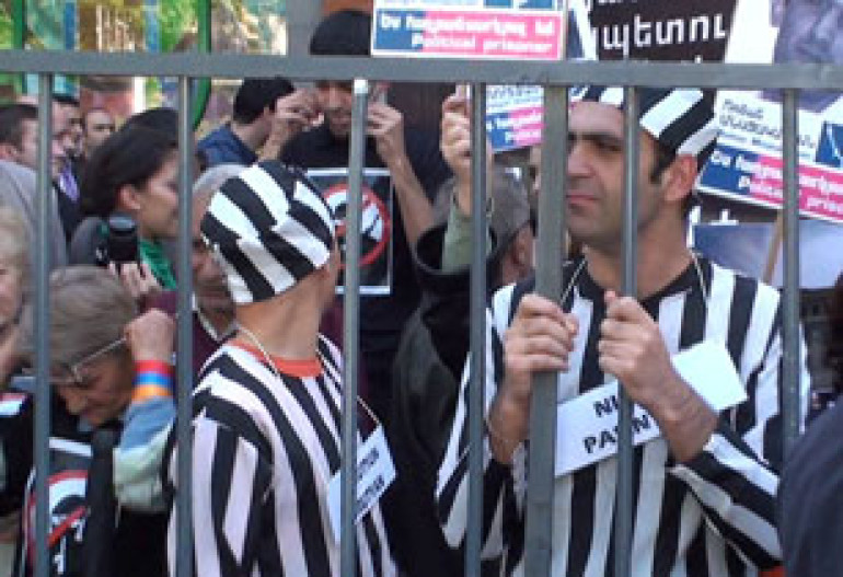 HAK activists welcome CoE forum’s participants with prison clothing, handcuffs and closed mouths