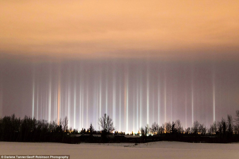 Extraordinary images show 'light pillars' dancing above houses after sunshine and snow combine to create rare effect