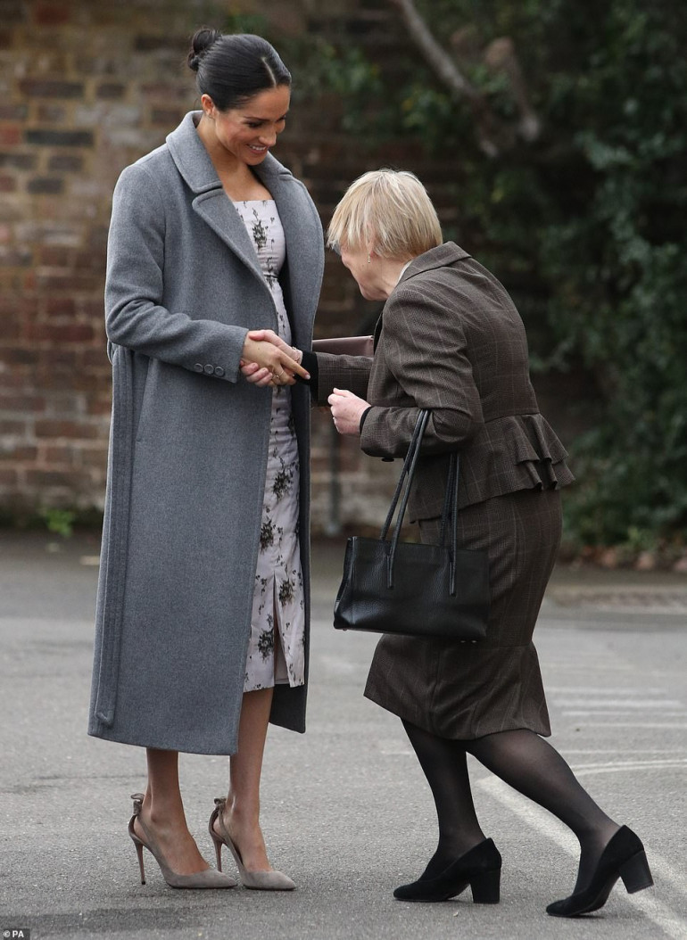 Pregnant Meghan Markle shows burgeoning baby bump in printed dress paired  with a 550 coat on visit to Royal Variety nursing home